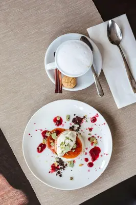 a table with two plates of food and a drink at Bed and Wine Nonsolovino in Reeuwijk