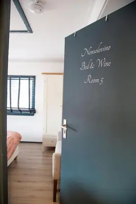 a blue door with a sign on it in a room at Bed and Wine Nonsolovino in Reeuwijk
