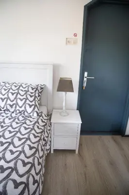 a bedroom with a bed and a night stand with a lamp at Bed and Wine Nonsolovino in Reeuwijk