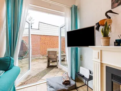 a living room with a tv and a fireplace at Holiday Home in Noordwijkerhout near Lake in Noordwijkerhout
