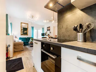 a kitchen with a stove top oven next to a living room at Holiday Home in Noordwijkerhout near Lake in Noordwijkerhout