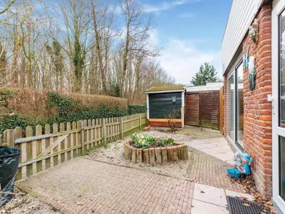 a backyard with a wooden fence and a garden at Holiday Home in Noordwijkerhout near Lake in Noordwijkerhout