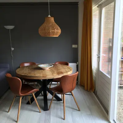 a dining room with a wooden table and chairs at Huize Beemsterlaan in Bergen