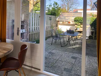 an open door to a patio with a table and chairs at Huize Beemsterlaan in Bergen