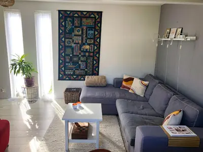 a living room with a blue couch and a table at Huize Beemsterlaan in Bergen