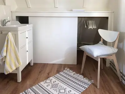 a bathroom with a sink and a chair and a desk at Huize Beemsterlaan in Bergen