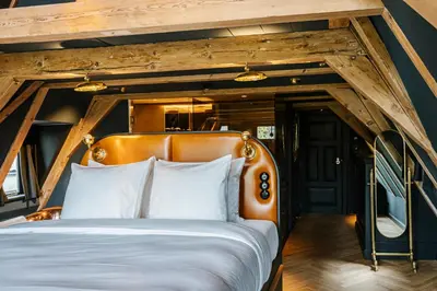 a bed in a room with a wooden ceiling at Boutique Hotel The Noblemen in Amsterdam