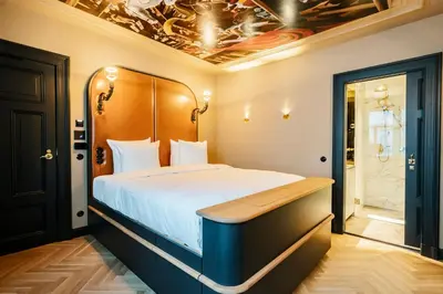 a bedroom with a bed with a wooden head board at Boutique Hotel The Noblemen in Amsterdam