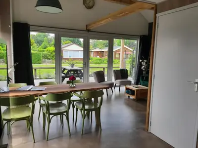 a dining room with a wooden table and chairs at Vakantievilla 10 km van strand honden welkom omheinde tuin sauna buitenbad in Dirkshorn