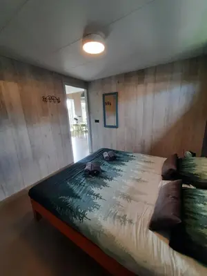 a bedroom with a large bed in a room at Vakantievilla 10 km van strand honden welkom omheinde tuin sauna buitenbad in Dirkshorn