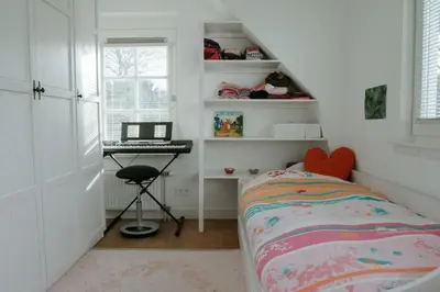 a bedroom with a bed and a desk with a laptop at Dune and Beach Villa with very large and beautiful Garden in Schoorl