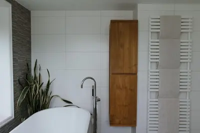 a bedroom with a bed and a wooden shelf at Dune and Beach Villa with very large and beautiful Garden in Schoorl