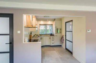 a kitchen with white cabinets and a sink at Villa Noordeinde in Bergen