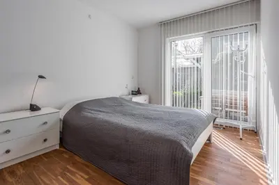 a bedroom with a bed and a large window at Villa Noordeinde in Bergen