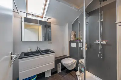 a bathroom with a sink and a toilet and a mirror at Villa Noordeinde in Bergen