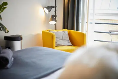a yellow chair in a room with a window at Modern Hideout Ace Location in Amsterdam