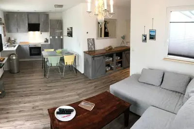 a living room with a couch and a table at Ferienhaus Good Times mit eigenem Steg Ferienpark Vislust Ijsselmeer in Wervershoof