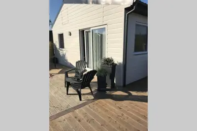 a patio with two chairs and a house at Ferienhaus Good Times mit eigenem Steg Ferienpark Vislust Ijsselmeer in Wervershoof