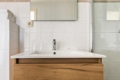 a bathroom with a sink and a mirror at Studio Parkweg in Bergen aan Zee