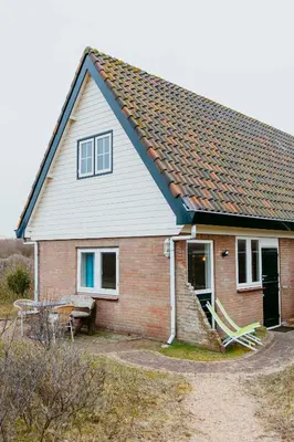 a small brick house with a bench in front of it at Studio Parkweg in Bergen aan Zee