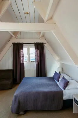 a bedroom with a large bed in the attic at Appartement Parkweg in Bergen aan Zee