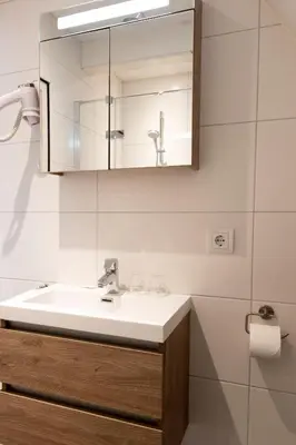 a bathroom with a sink and a mirror at Appartement Parkweg in Bergen aan Zee