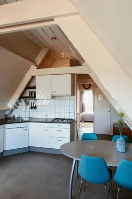 a kitchen and dining room with a table and chairs at Appartement Parkweg in Bergen aan Zee