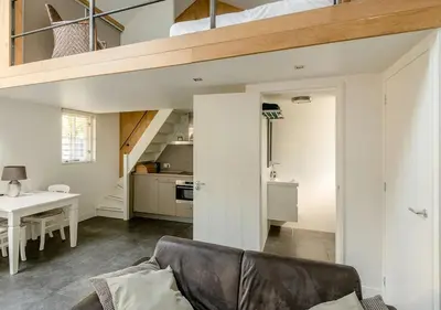 a living room with a couch and a loft at Slaperij ‘t Woud - Near the dunes and the sea! in Bergen