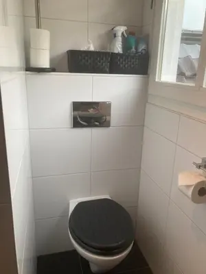 a bathroom with a black toilet and a window at B&BOosterweg3 Studio - Free private parking in Heemskerk