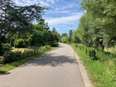 a winding road with trees on both sides at B&BOosterweg3 Studio - Free private parking in Heemskerk
