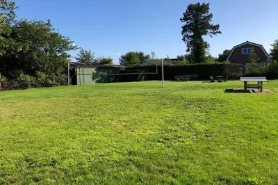 a park with a picnic table in the grass at Have a nice stay! - Vakantiehuis de Schelp op rustig park in Noordwijk