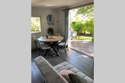 a living room with a couch and a table at Have a nice stay! - Vakantiehuis de Schelp op rustig park in Noordwijk