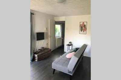 a living room with a couch and a television at Have a nice stay! - Vakantiehuis de Schelp op rustig park in Noordwijk