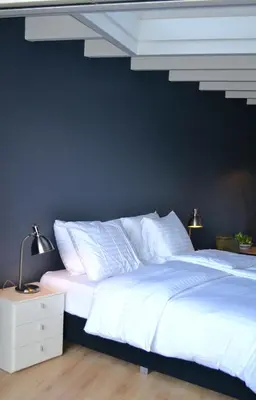 a bedroom with two white beds and a blue wall at Studio/appartment EVI in Zandvoort