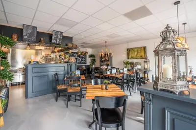 a restaurant with tables and chairs and a bar at Luxe Chalet Marbella IJmuiden aan Zee in IJmuiden