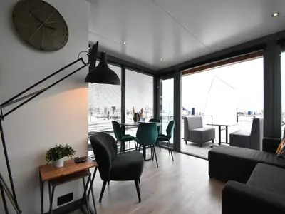a living room with a clock and a table and chairs at Boat in Volendam near Marina Museum in Volendam