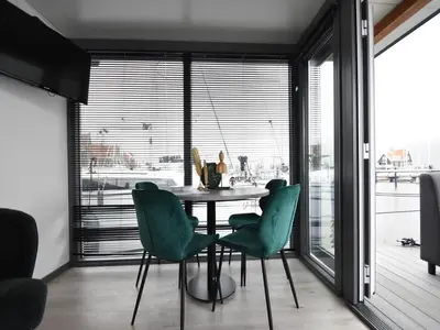 a dining room with a table and green chairs at Boat in Volendam near Marina Museum in Volendam