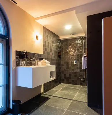 a bathroom with a sink and a shower at Relais & Châteaux Weeshuis Gouda in Gouda