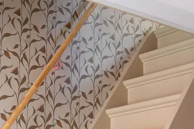 a staircase with a floral wallpaper on the wall at Relais & Châteaux Weeshuis Gouda in Gouda