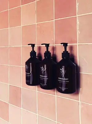 three bottles of laundry detergent on a tile wall at Relais & Châteaux Weeshuis Gouda in Gouda