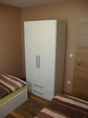 a bedroom with a large white cabinet next to a bed at Ferienpark Vislust Modernes Holzhaus am Ijsselmeer mit eigenen Steg in Wervershoof