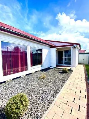 a white house with a red roof at Ferienpark Vislust Modernes Holzhaus am Ijsselmeer mit eigenen Steg in Wervershoof