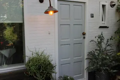 a white door on a house with a lamp at Klein Oldenburg in Bergen