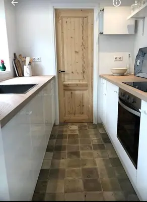 a kitchen with white counters and a wooden door at Klein Oldenburg in Bergen