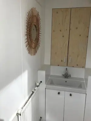 a white bathroom with a sink and a mirror at Klein Oldenburg in Bergen