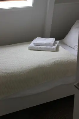 a bed with two towels sitting on top of it at Klein Oldenburg in Bergen