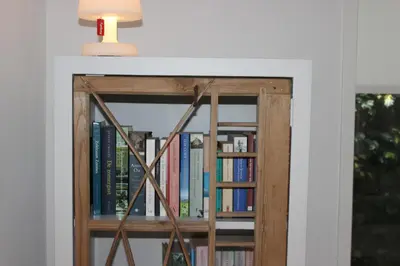 a book shelf filled with books with a light on top at Klein Oldenburg in Bergen