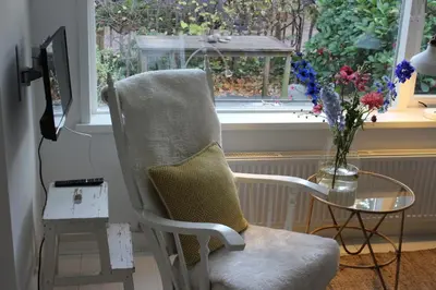 a chair and a table in a room with a window at Klein Oldenburg in Bergen