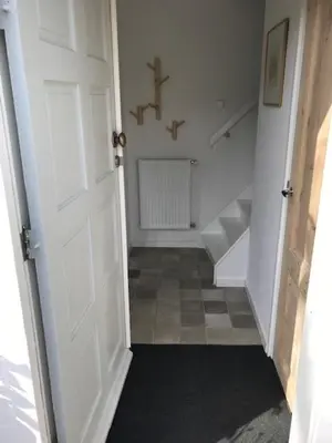 a hallway with a white door and a cross on the wall at Klein Oldenburg in Bergen