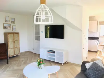 a living room with a tv and a table at Bendalong Noordwijk in Noordwijk